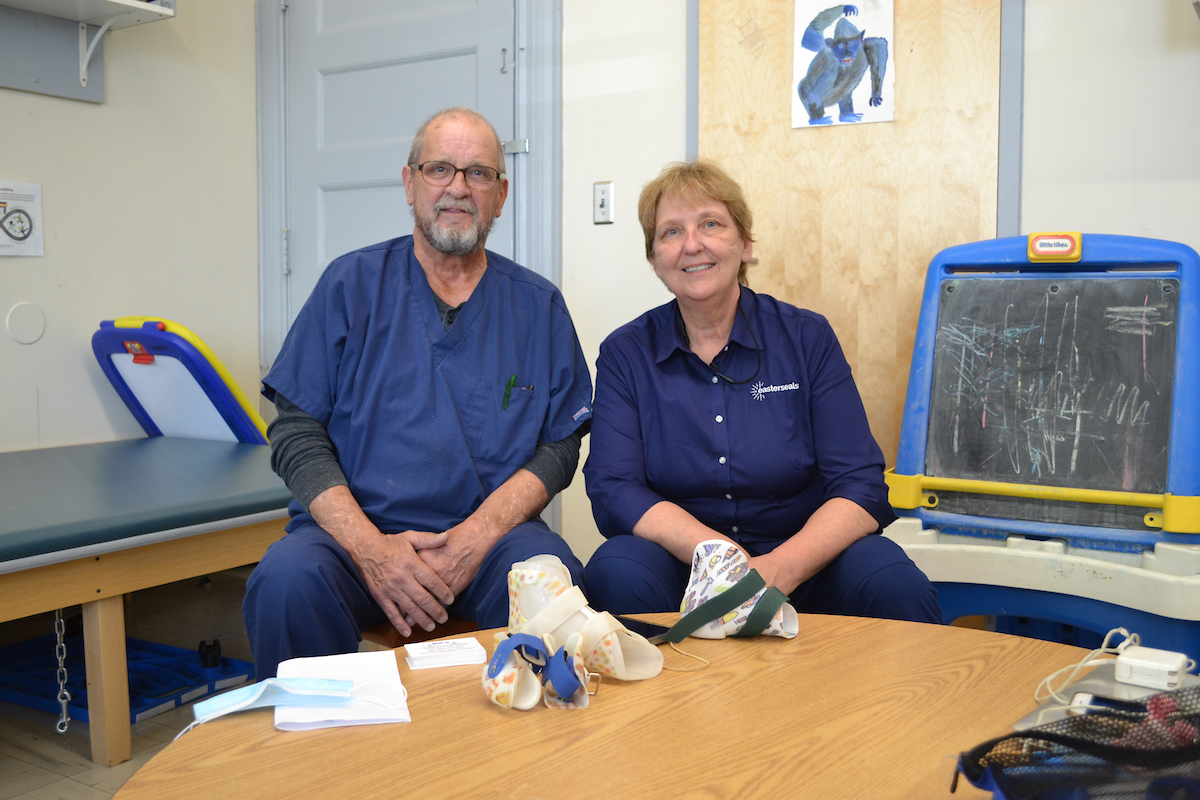 Bob with Donna Cordova, Easterseals NH Early Supports & Services pediatric physical therapist. Several of Bob’s orthotics are displayed on the table.