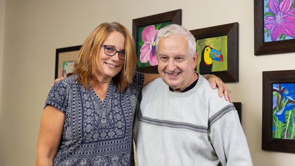 Adult day client and staff smiling for photo.