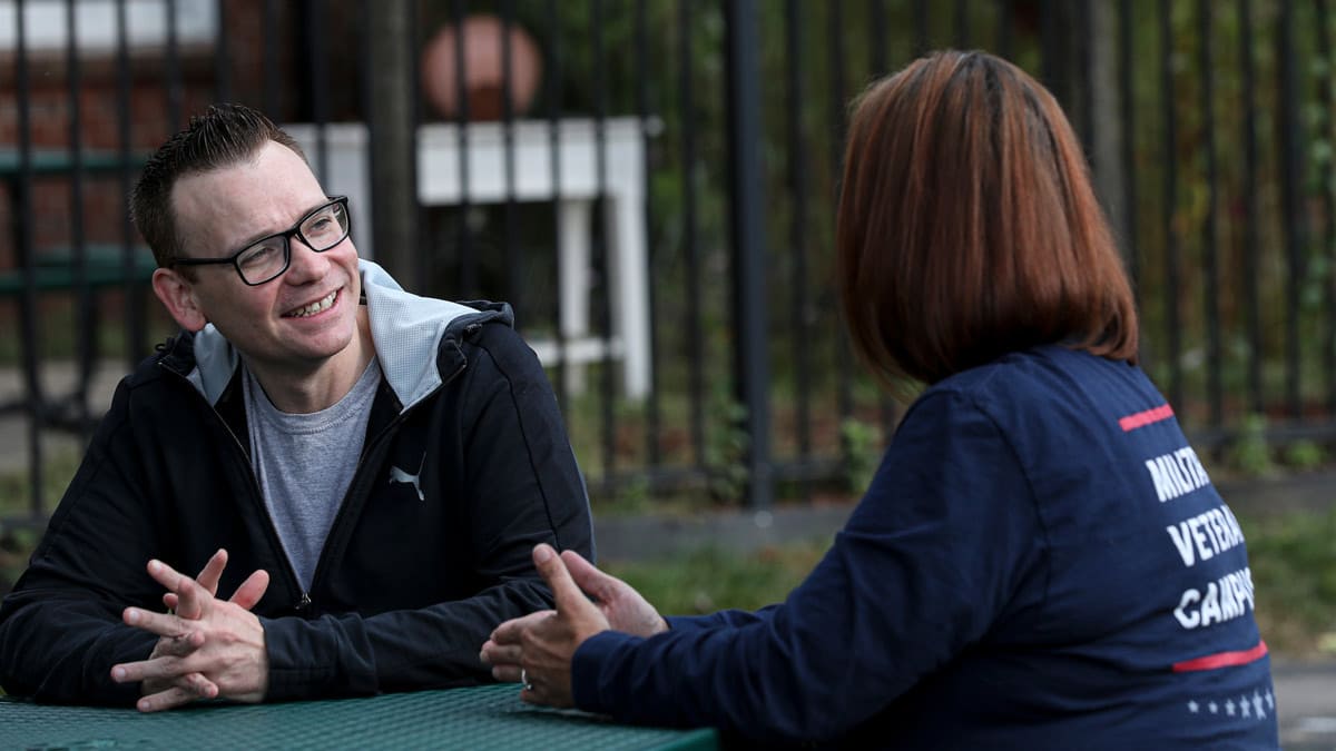 Chris and Veterans Count care coordinator sitting at a table outside having a conversation.